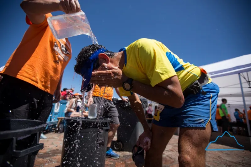 Voluntarios de primera, agua helada, el refresco perfecto para Gustavo Reyes antes de iniciar el descenso. Foto: Rodrigo Lizama | Trail Running Argentina.